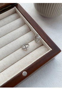 Detail view of S999 sterling silver hoop earrings with zircon cross in a jewelry box