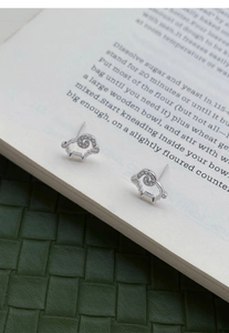 Dettaglio degli orecchini a pecora in argento con design cavo e corna di zircone
