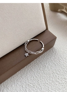Détail de la bague en argent S925 avec pendentif étoile et design de chaîne en zircone