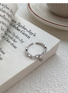 Vue détaillée de la bague étoile en argent S925 sur une page de livre blanche pure