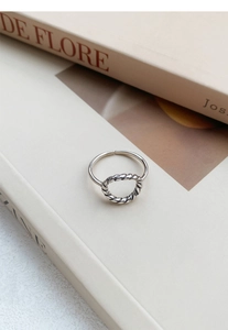 Vue détaillée bague S925 en argent sterling avec noeud torsadé sur un livre ancien