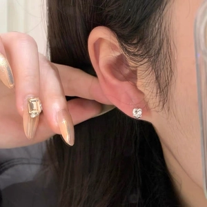 Elegant heart-cut S999 sterling silver rose heart stud earrings shown on model ear