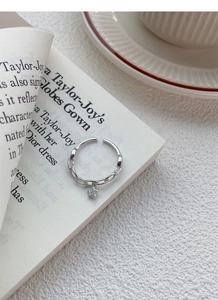 Détail d'une bague étoile en argent S925 avec maillons de chaîne sur un livre ouvert