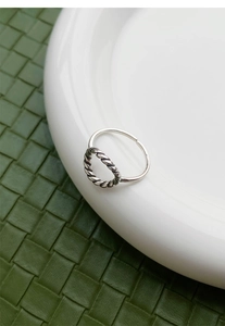 Vue macro détaillée de la texture torsadée et du design ajouré circulaire sur bague argent S925