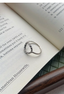 Détail du design torsadé et du motif circulaire évidé sur la bague en argent S925