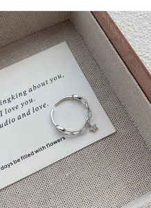 Détail d'une bague chaîne en argent S925 avec breloque étoile et texture tressée
