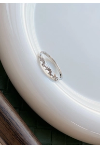 Macro detail of S999 sterling silver wheat leaf ring with shimmering zircon stones