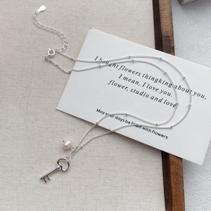 Elegant S925 sterling silver key pendant necklace with a white pearl on a minimalist chain