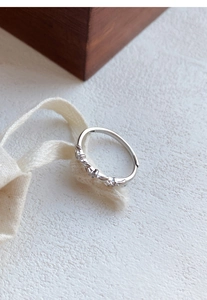 Macro detail of S999 silver wheat ring with zircon inlay on a rustic background
