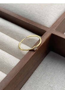 Detail of minimalist gold S925 silver ring with sparkling round cubic zirconia gem