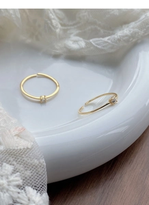 Close-up of gold S925 silver adjustable open rings with sparkling single zircon stones