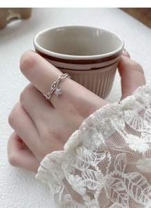 Bague chaîne en argent avec pendentif étoile portée dans un décor lifestyle élégant