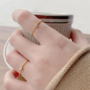 Minimalist S925 sterling silver gold ring with round cubic zirconia on model holding cup