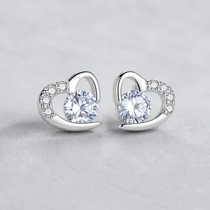 Vue macro de boucles d'oreilles en forme de cœur en argent avec cristaux et zircons