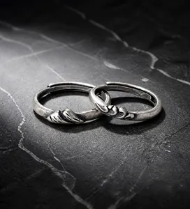 Gros plan de bagues de couple en argent vintage avec gravures de montagne et de vagues