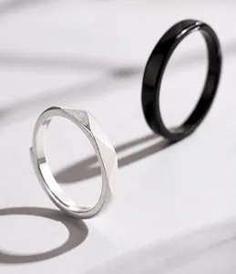 Détail de bagues de couple réglables en argent mat et noir lisse pour amoureux