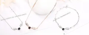 Detail view of silver reindeer antler projection necklaces and bamboo style bracelet