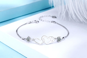 Detailed macro view of S925 silver double interlocking heart bracelet with moissanite stones