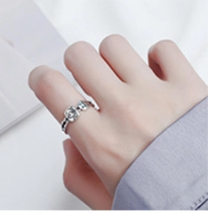Close-up of a vintage hollow silver ring worn on index finger with a square signet design