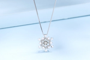 Macro shot of silver S925 snowflake pendant with sparkling cubic zirconia on blue steps