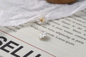 Macro shot of S925 sterling silver daisy stud earrings with detailed golden stamens