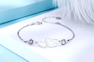 Detailed shot of S925 silver double heart bracelet with purple cubic zirconia stones