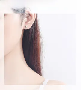 Close-up of minimalist S925 sterling silver star stud earrings with zircon stones on model
