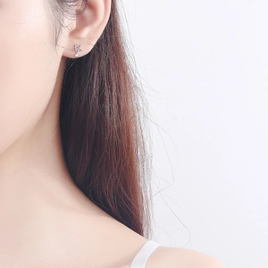 S925 Sterling Silber Stern Ohrstecker mit kleinem Diamanten am Ohrläppchen eines Models