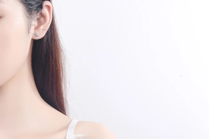 Detailed view of silver snowflake stud earring with sparkling cubic zirconia on model