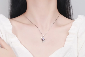 Close-up of heart-shaped S925 silver necklace with purple gemstone and pavé stones