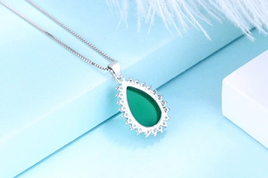 Détail du pendentif en calcédoine verte en forme de goutte avec pierres sur chaîne argent