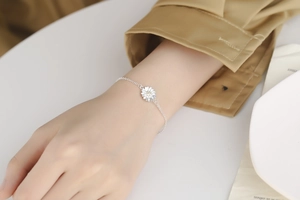 Detail view of S925 sterling silver daisy bracelet worn on wrist with delicate floral charm