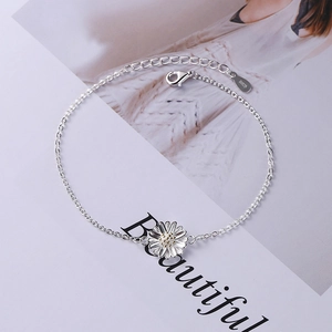 Elegant S925 sterling silver daisy bracelet with gold accents on a fashion magazine background