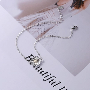 Elegant S925 sterling silver daisy bracelet with gold accent on fashion magazine