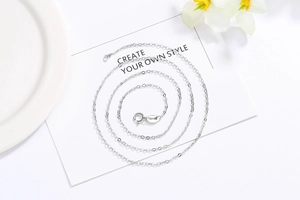 Macro view of a thin S925 sterling silver water wave chain with a spring ring clasp