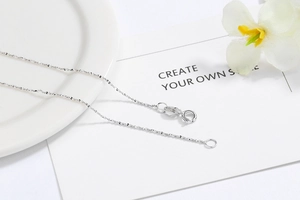 Macro shot of S925 sterling silver water wave chain necklace with spring clasp and engraving