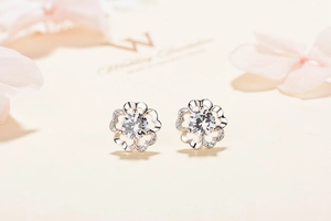 Macro detail of S925 silver flower stud earrings featuring a central cubic zirconia stone