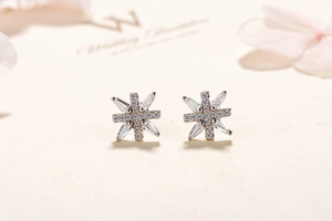 Macro shot of silver snowflake earrings with sparkling round and baguette-cut zircons