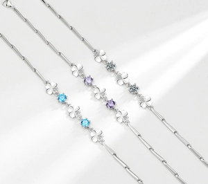 Dettaglio di braccialetti quadrifoglio in argento S925 con gemme blu, viola e bianche