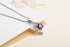 Macro detail of S999 silver dolphin pendant with purple zircon and delicate box chain