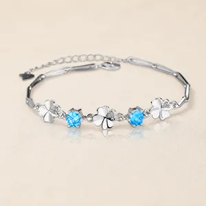Macro view of S925 silver bracelet featuring hollow clovers and blue round gemstones