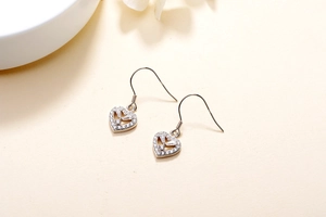Detailed macro view of S925 sterling silver heart earrings with sparkling cubic zirconia
