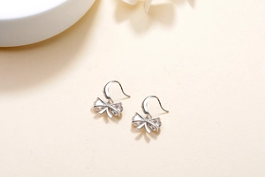 Detail of S925 sterling silver bow earrings with sparkling zircon stones and hook closures