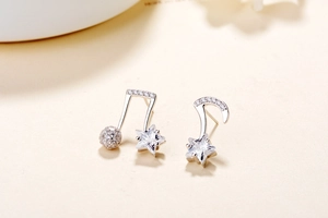 Close-up of asymmetric S925 silver music note stud earrings with sparkling star zircons