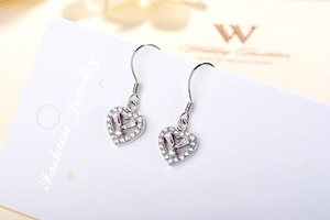 Macro detail of S925 sterling silver heart earrings with sparkling micro-pave crystals