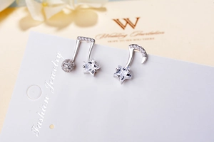 Detailed macro of S925 sterling silver music note earrings with zircon and star charms