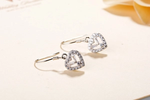 Macro shot of S925 sterling silver heart earrings with French hooks and sparkling zircons