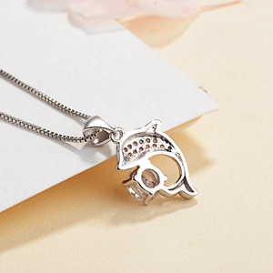 Elegant S999 sterling silver dolphin necklace with sparkling zircon on a warm beige backdrop