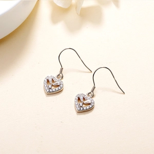 Elegant S925 sterling silver heart drop earrings with white zircon on a beige surface