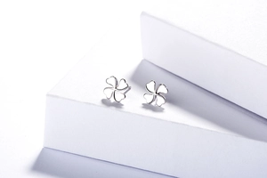 Vue détaillée de boucles d'oreilles trèfle à quatre feuilles en argent sur socle